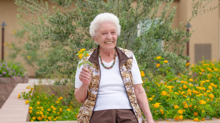 A joyful resident enjoys the vibrant garden, embodying warmth and community spirit.