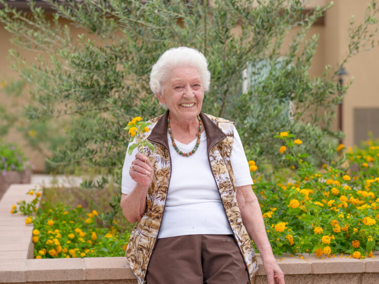 A joyful resident enjoys the vibrant garden, embodying warmth and community spirit.