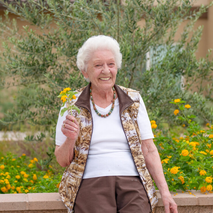 A joyful resident enjoys the vibrant garden, embodying warmth and community spirit.