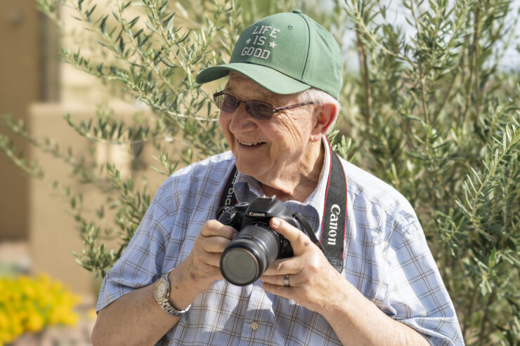 A cheerful resident enjoys capturing moments, surrounded by nature's beauty, fostering community spirit.