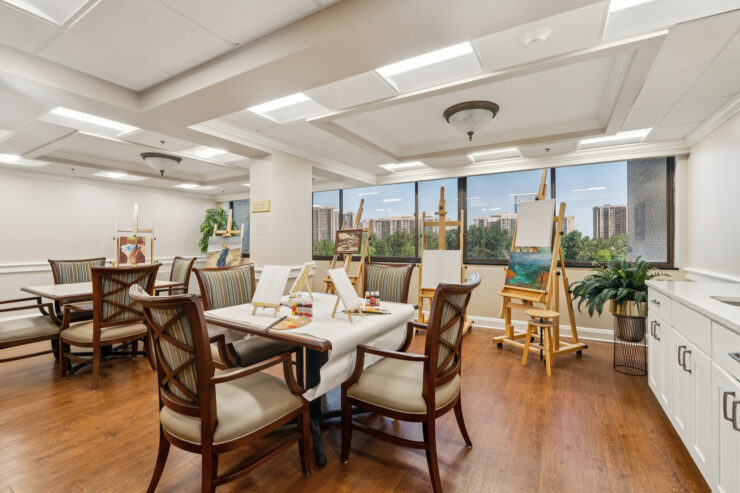 A bright art studio invites creativity, featuring easels, vibrant paints, and a welcoming atmosphere.