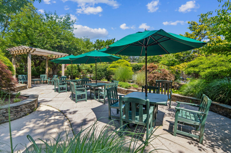 Inviting outdoor seating surrounded by lush greenery creates a welcoming community atmosphere.