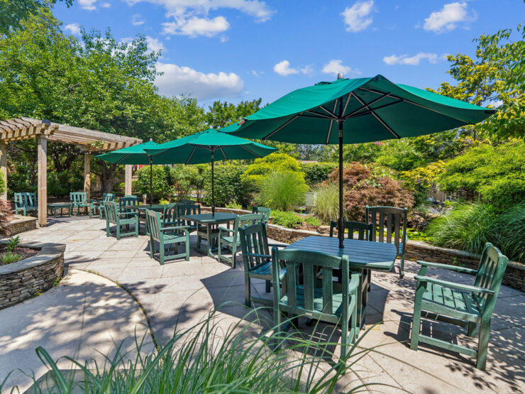 Inviting outdoor seating surrounded by lush greenery creates a welcoming community atmosphere.