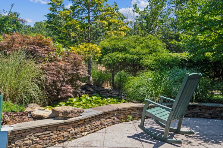 A serene garden retreat with lush greenery and a tranquil pond, inviting relaxation and community bonding.