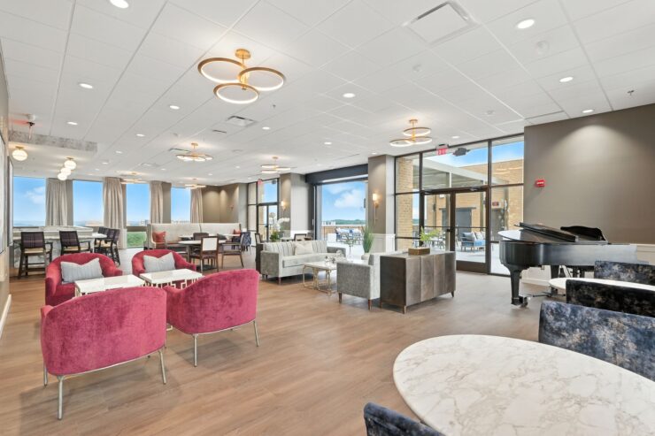 A welcoming lounge with elegant seating, bright windows, and a piano, fostering community and comfort.