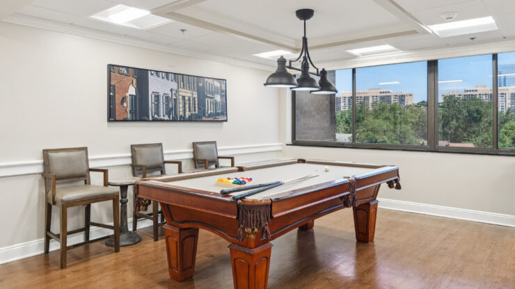 A welcoming game room with a pool table, inviting seating, and bright natural light, perfect for socializing.