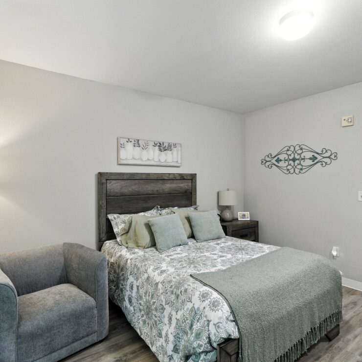 A serene bedroom featuring soft colors and inviting furnishings, perfect for restful living.