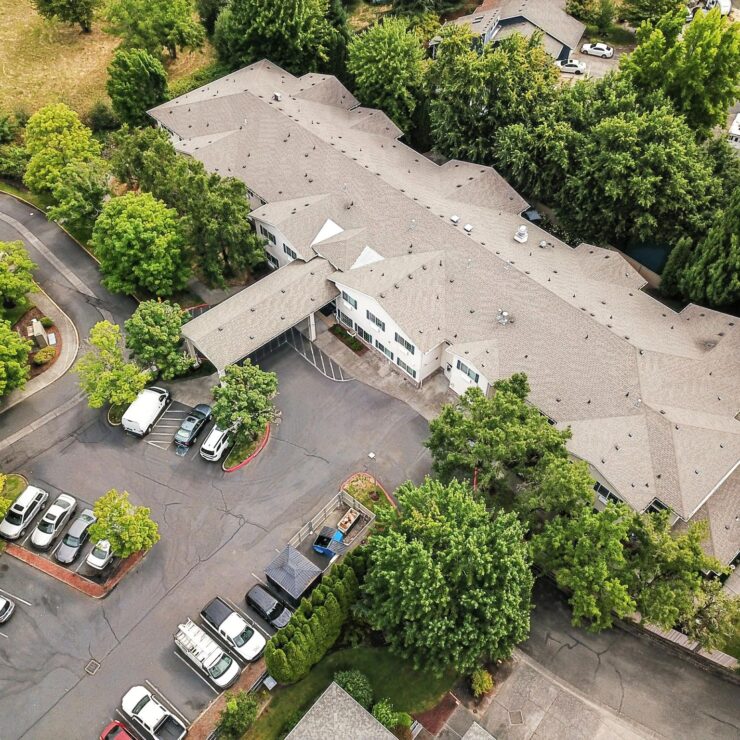 A welcoming retirement community surrounded by lush greenery and ample parking, fostering connection.