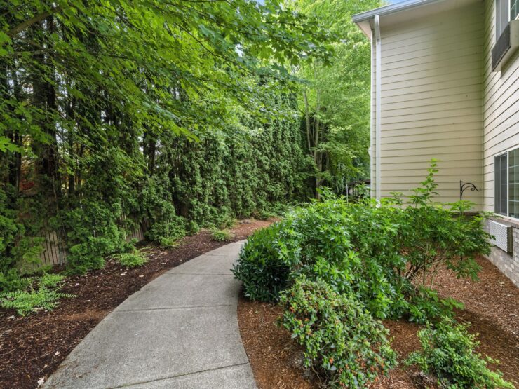 A serene pathway winds through lush greenery, inviting residents to enjoy peaceful outdoor moments.