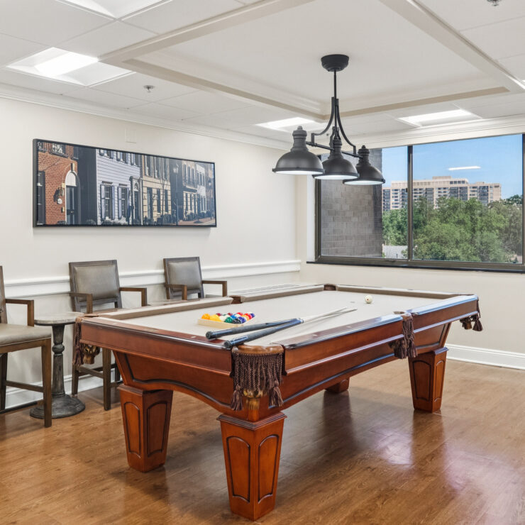 A bright game room invites friendly gatherings, featuring a stylish pool table and scenic views.