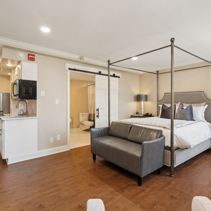A welcoming suite with a stylish bed and inviting seating, perfect for relaxation and community living.