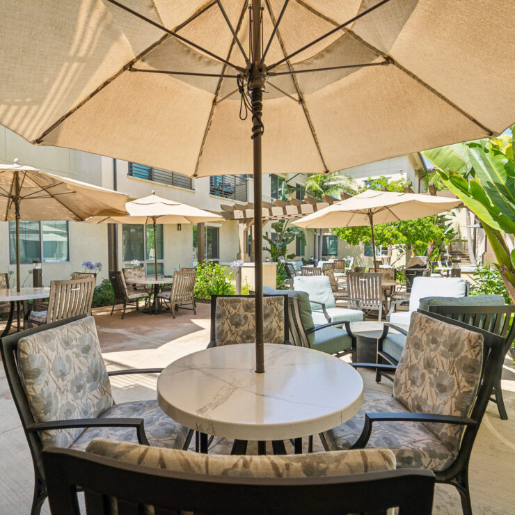 A serene outdoor space with inviting seating, shaded by umbrellas, fostering community and relaxation.