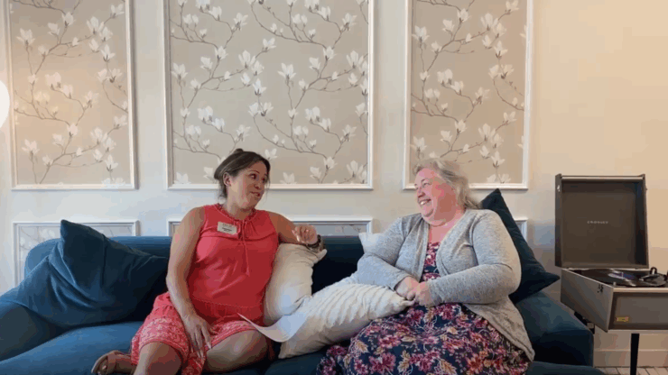 Two residents share a joyful conversation on a comfortable couch, surrounded by a warm, inviting atmosphere.