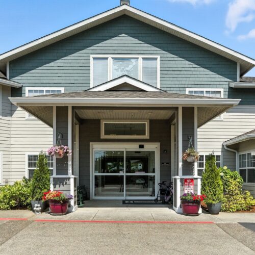 Welcoming entrance adorned with vibrant flowers, inviting residents to a warm, friendly community.