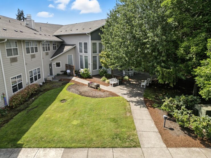 A serene garden invites relaxation, featuring lush greenery and inviting seating for community gatherings.