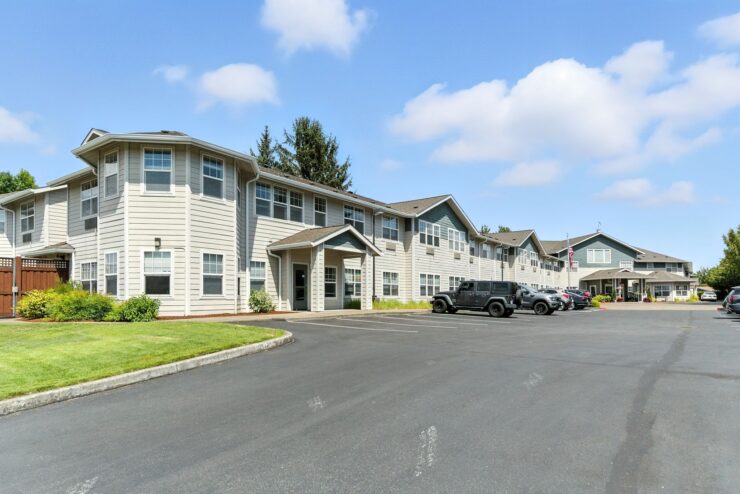 A welcoming retirement community surrounded by lush greenery, fostering connection and comfort.