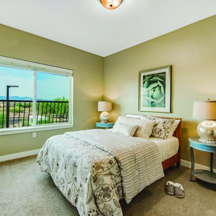 A serene bedroom filled with natural light, offering a warm, inviting space for relaxation and community.