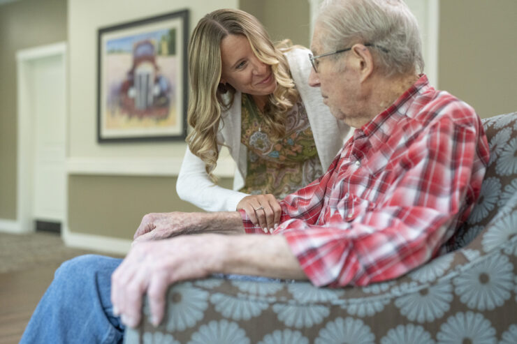 A warm interaction between a caregiver and resident fosters a sense of community and support.