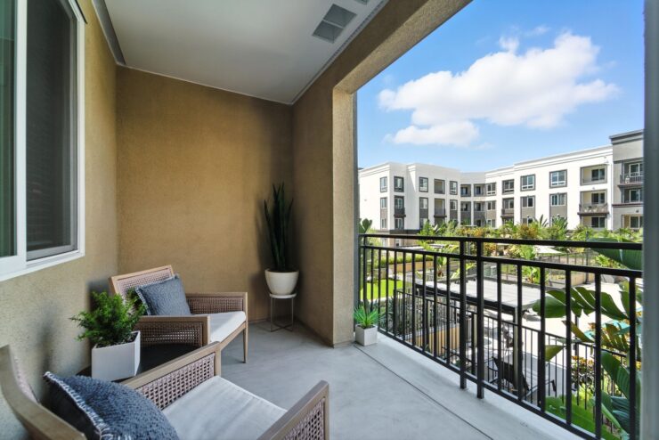 A serene balcony invites relaxation, showcasing a vibrant community and beautiful outdoor views.
