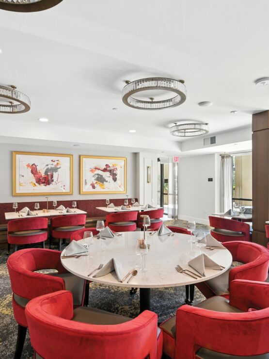 Bright dining area with inviting red chairs, creating a warm atmosphere for community gatherings.