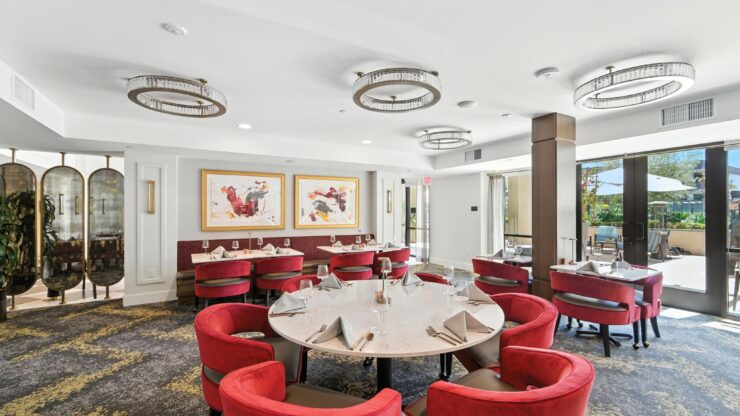 Bright dining area with inviting red chairs, creating a warm atmosphere for community gatherings.