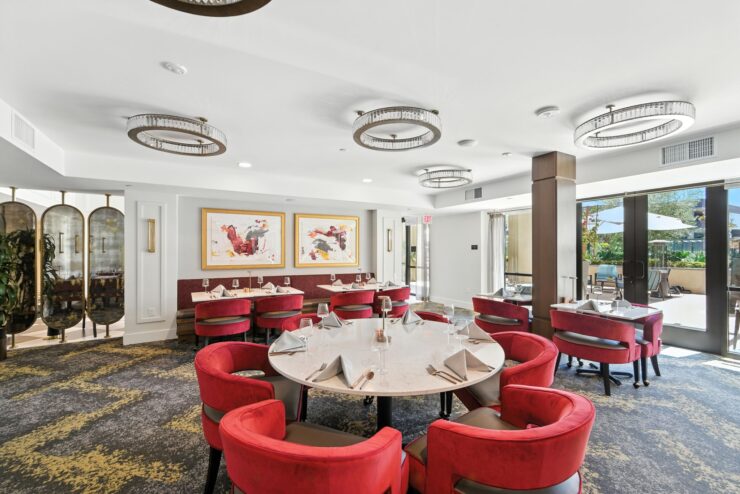 Bright dining area with inviting red chairs, creating a warm atmosphere for community gatherings.