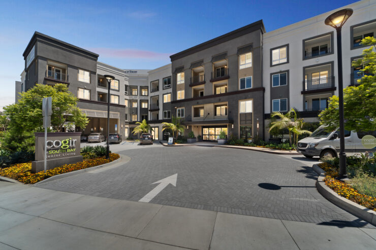 A welcoming entrance showcases vibrant landscaping and modern architecture, inviting residents to a warm community.