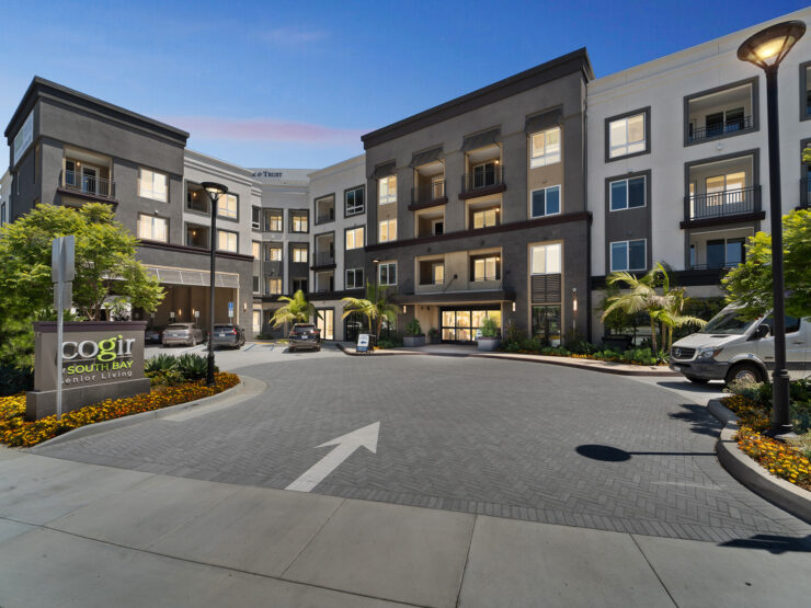 A welcoming entrance showcases vibrant landscaping and modern architecture, inviting residents to a warm community.