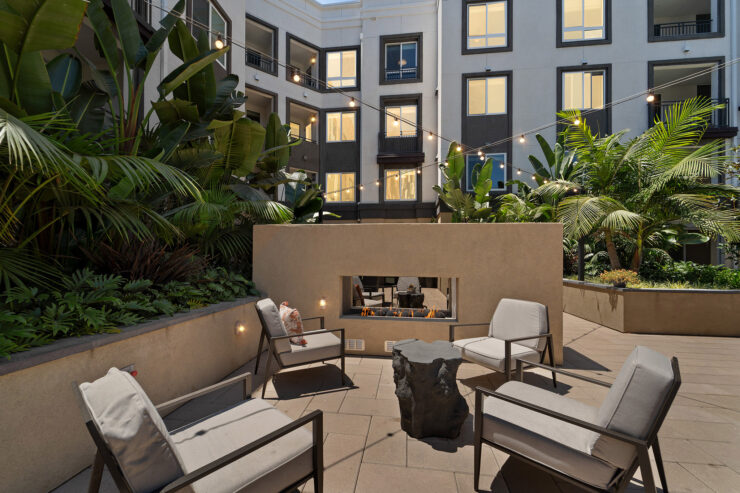 A welcoming courtyard features comfortable seating and lush greenery, creating a serene community space.