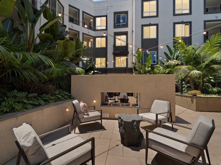 A welcoming courtyard features comfortable seating and lush greenery, creating a serene community space.