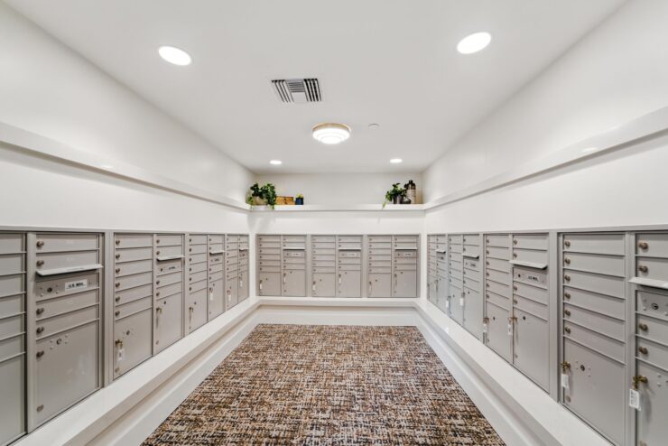 A welcoming mailroom featuring organized mailboxes, bright lighting, and a warm atmosphere for residents.