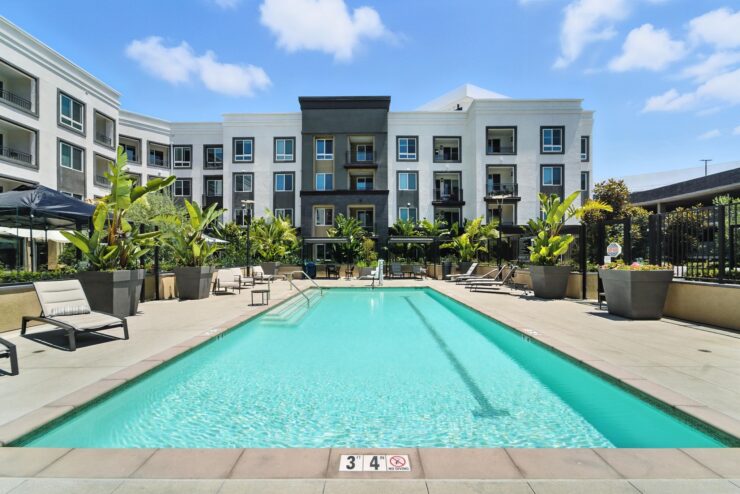 A serene poolside setting invites residents to relax and enjoy community gatherings under bright skies.