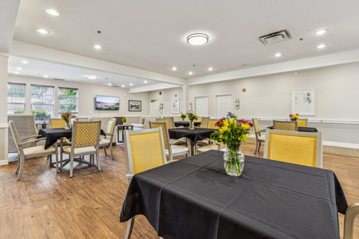 Bright, welcoming dining area with cheerful flowers, inviting tables, and a sense of community.