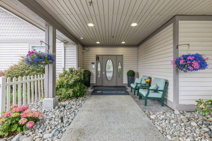 Welcoming entrance adorned with vibrant flowers, inviting seating, and a sense of community.