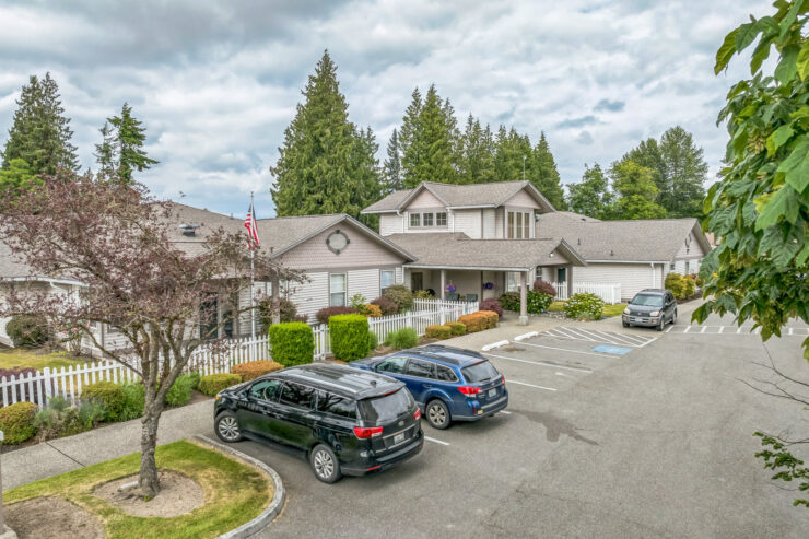 A welcoming community with beautiful greenery, inviting homes, and accessible parking for residents.