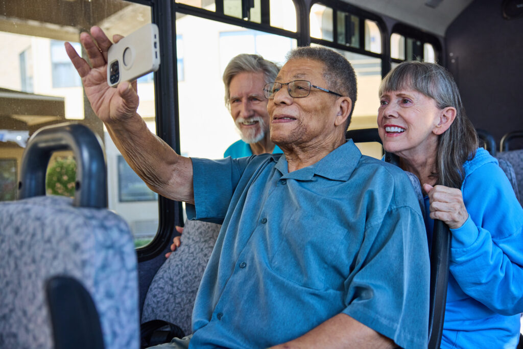 Friends enjoy a joyful moment on a bus, capturing smiles and laughter, highlighting community spirit.