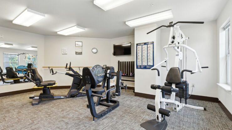 A bright, inviting fitness room equipped with modern exercise machines, fostering health and community.