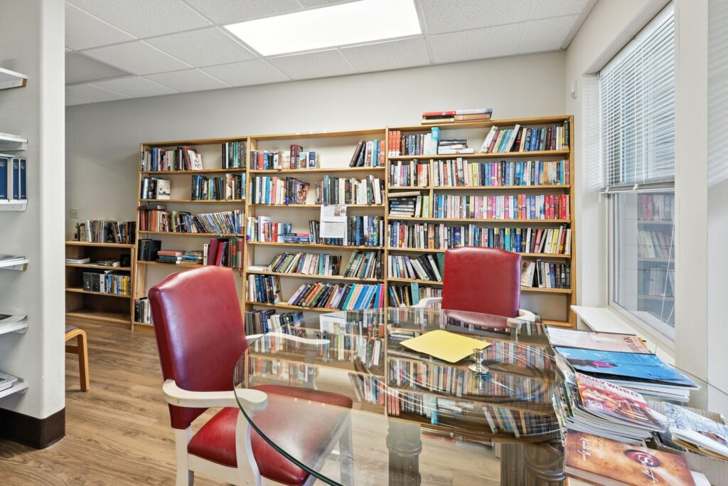 A welcoming reading nook with vibrant bookshelves, inviting chairs, and a bright, cheerful atmosphere.