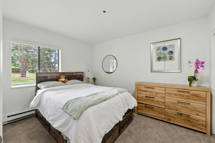 A serene bedroom featuring natural light, inviting decor, and a warm atmosphere for relaxation.