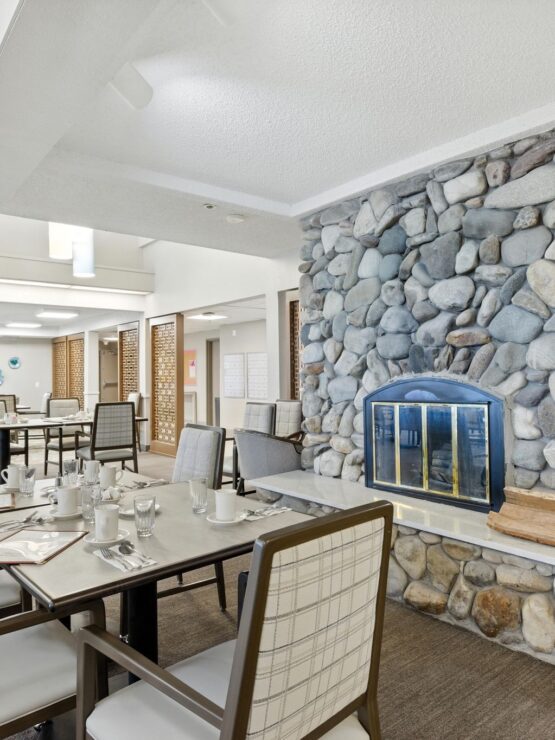 Bright and inviting dining area with stone fireplace, fostering warmth and community spirit.