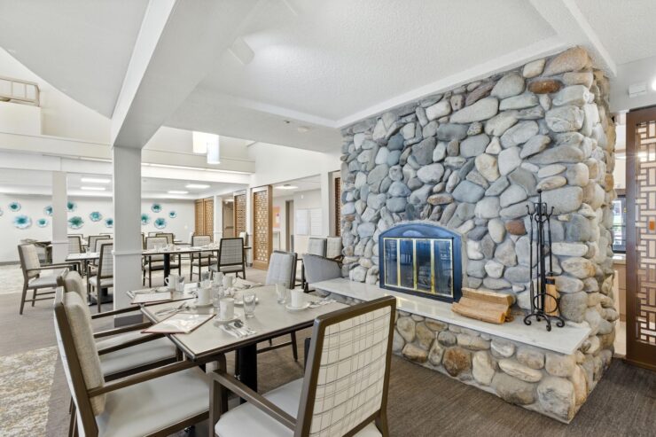 Bright and inviting dining area with stone fireplace, fostering warmth and community spirit.