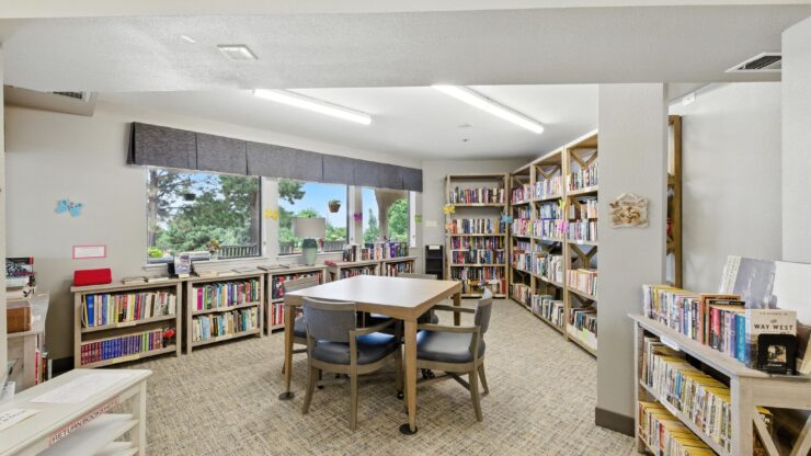 A welcoming library space with ample natural light, inviting residents to enjoy reading and community connection.