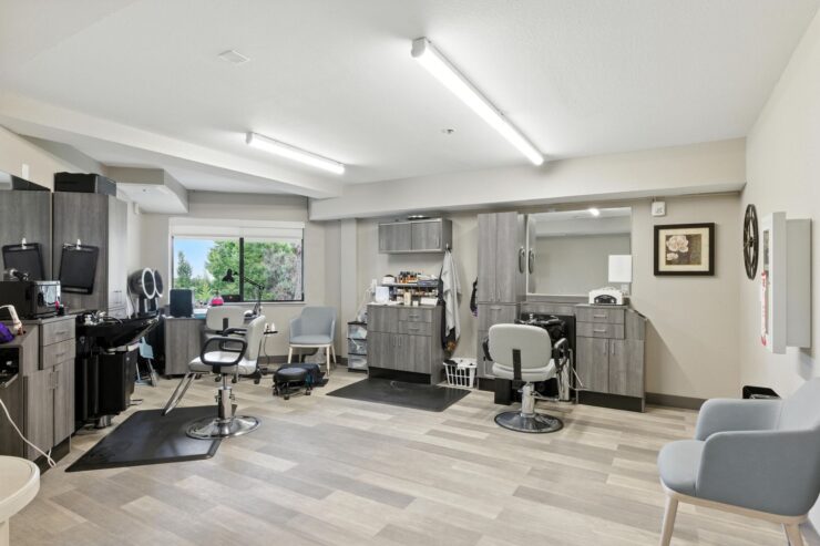 A welcoming salon space, filled with natural light, fostering community and relaxation for residents.