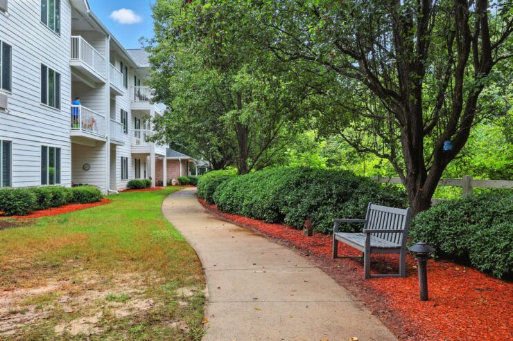 Lush greenery frames a welcoming path, inviting residents to enjoy leisurely strolls and community moments.