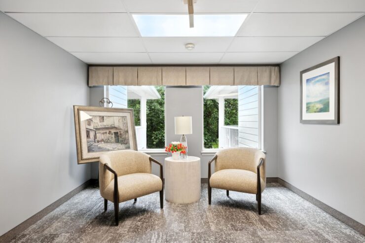 A serene sitting area invites relaxation, featuring soft chairs, warm lighting, and lovely artwork.