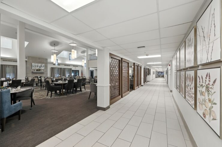 A bright, welcoming corridor leads to a dining area, fostering community and comfort for residents.