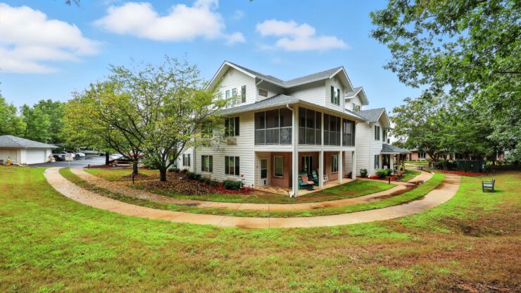 A welcoming retirement community surrounded by lush greenery, promoting comfort and connection.