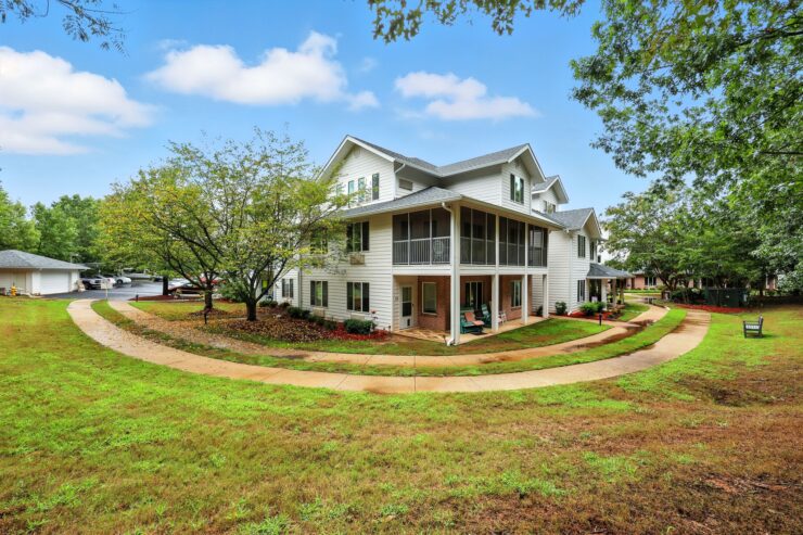 A welcoming retirement community surrounded by lush greenery, promoting comfort and connection.