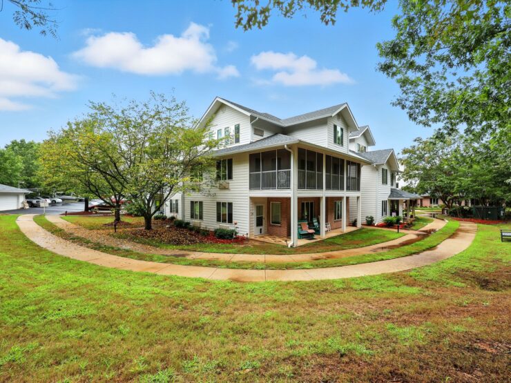 A welcoming retirement community surrounded by lush greenery, promoting comfort and connection.