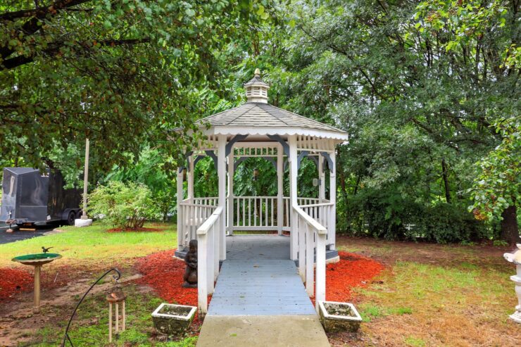 A charming gazebo nestled among lush greenery, creating a serene space for community gatherings and relaxation.